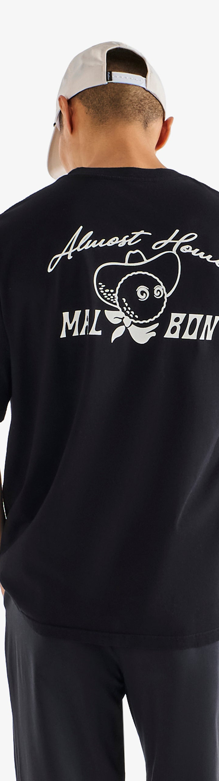 Person wearing a black t-shirt with white text and graphics on the back, standing against a white background.